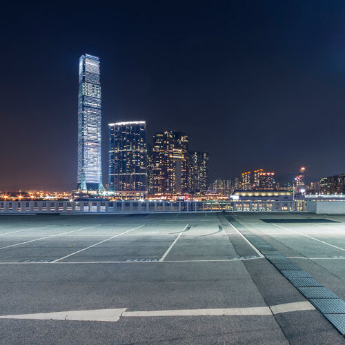 empty parking lot against a city skyline at night