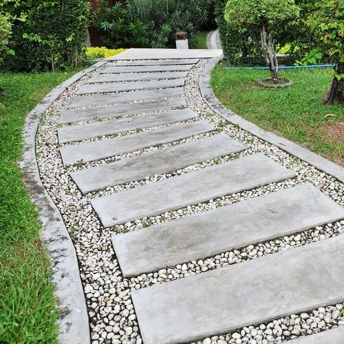 A Stone Garden Walkway With Concrete Curbing.