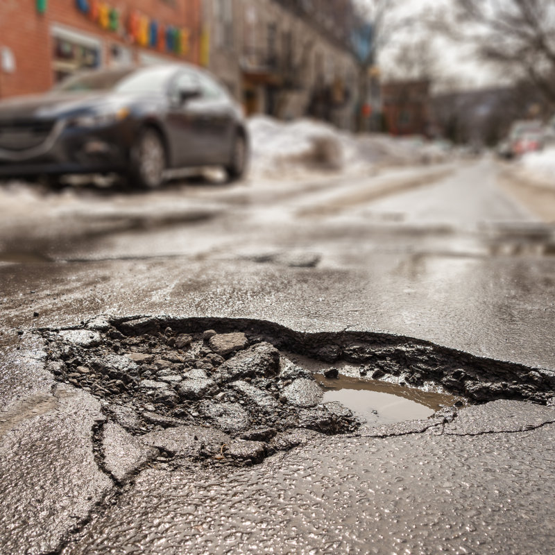 close-up of a pothole on a busy road
