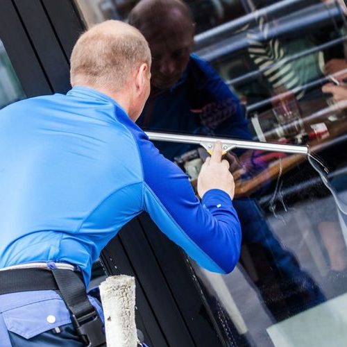 A Picture of a Man Washing Windows.