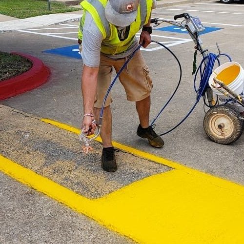 A Picture of a Man Adding Paint To Speed Bump.