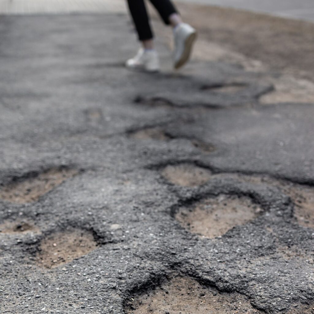 person jogging past a line of potholes