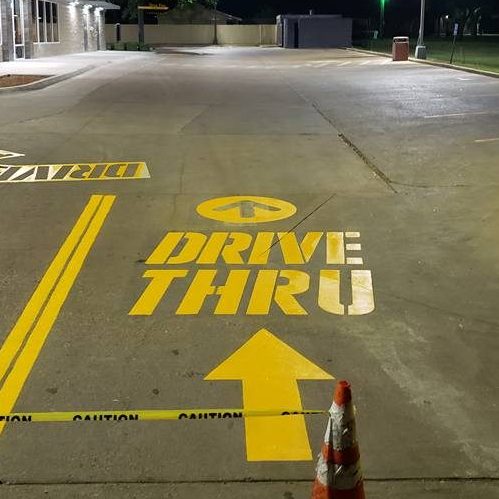 A Picture of Yellow Paint On Ground That Says Drive Thru.